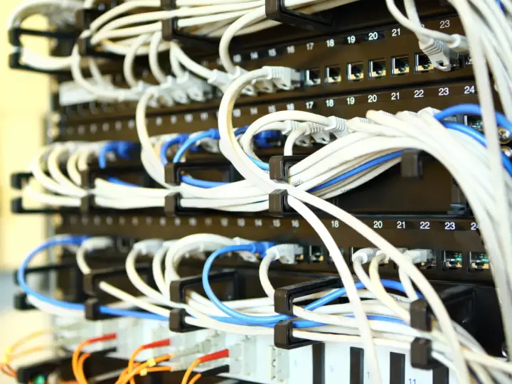 A server rack filled with network switches and hundreds of wires connecting everything together