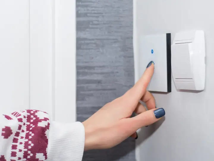 A smart switch is being pushed on to turn on the lights